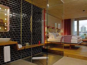 een badkamer met een bed en een glazen douche bij 25hours Hotel Langstrasse in Zürich