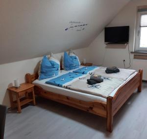 - une chambre avec un grand lit et des oreillers bleus dans l'établissement Gästehaus Mia, à Norddeich