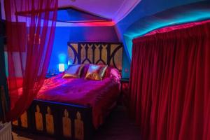 een slaapkamer met een bed met rode en blauwe gordijnen bij Hotel Pelirocco in Brighton & Hove