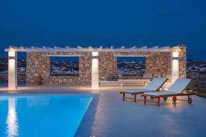 Villa Conza Mykonos في أغيوس يوانيس ميكونوس: فيلا بمسبح في الليل