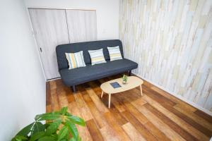 um sofá azul numa sala de estar com uma mesa em stay's サンジョイフル 304号 名古屋 民泊 駅近 em Nagoya