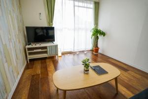 uma sala de estar com uma mesa e uma televisão de ecrã plano em stay's サンジョイフル 304号 名古屋 民泊 駅近 em Nagoya