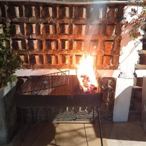 een stenen open haard met een tafel ervoor bij Monoambiente en Colonia in Colonia del Sacramento