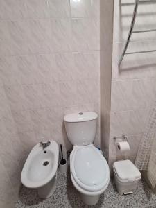 uma casa de banho com um WC branco e um lavatório. em Scenic Comfort D em Ponta Delgada