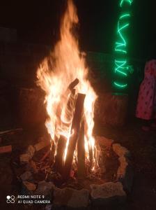 een persoon die rond een vuur in een vuurplaats staat bij KODAIKANAL HOME STAY in Kodaikānāl