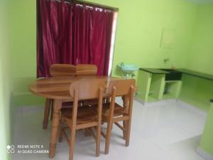 een houten tafel en stoelen in een kamer bij KODAIKANAL HOME STAY in Kodaikānāl