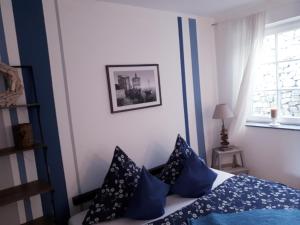 Un dormitorio con una cama con almohadas azules y una ventana en Ferienwohnung am Spreeradweg in Bautzen, en Bautzen