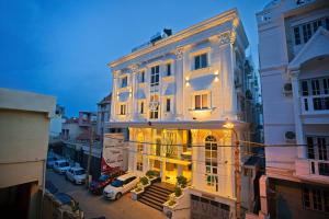 een wit gebouw met verlichting in een stadsstraat bij Livaana in Mysore