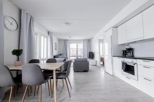 una cucina e una sala da pranzo con tavolo e sedie di Apartment, SleepWell, Nuutti a Turku