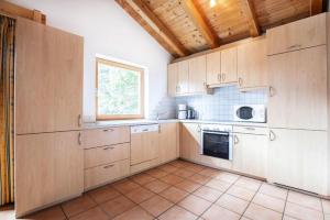 cocina grande con armarios de madera y ventana en Chalet, Hochkrimml, en Krimml