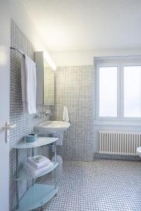 a bathroom with a sink and a toilet and a window at Gasthof zum Schützen in Aarau