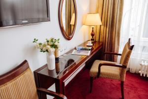 a hotel room with a desk and a mirror at Garni Hotel Planeta Inn in Novi Sad