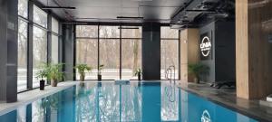 uma piscina num edifício com janelas e uma piscina em Apartamenty IMPRESSA BASEN - SPA - SAUNA Lublin Centrum em Lublin