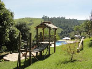 um parque infantil com um gazebo ao lado de uma piscina em Pousada Morro Verde em Águas de Lindóia