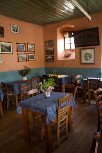 uma sala de jantar com mesa e cadeiras e um relógio em Napoleon Zaglis Guesthouse em Kalarrites