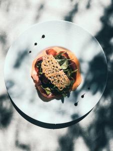 ein weißer Teller mit einem Sandwich darüber in der Unterkunft Auberge Des Pins in Tourrettes