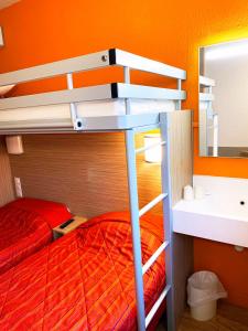 een slaapkamer met een stapelbed en een spiegel bij Premiere Classe Valence - Bourg Les Valence in Bourg-lès-Valence