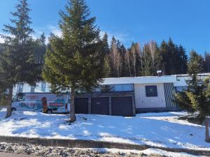 um camião estacionado em frente a um edifício na neve em Hotel Forest em Pale