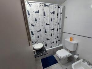 a bathroom with a toilet and a shower curtain at Departamento Torre Murguía in San Salvador de Jujuy