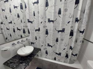 a bathroom with a sink and a shower curtain at Departamento Torre Murguía in San Salvador de Jujuy