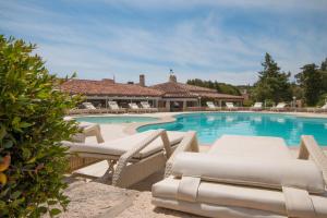 una piscina con tumbonas y una casa en Hotel Nibaru, en Porto Cervo