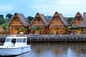 um barco na água em frente a um edifício em Pelican Lodge & Marina em Entebbe