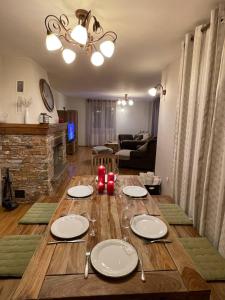 a wooden table with plates and wine glasses on it at Remarkable home Bohinj Lake in Bohinj