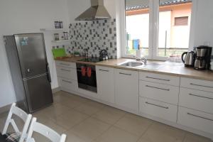 cocina con armarios blancos y nevera de acero inoxidable en Big holiday home in Lukecin for 9 persons, en Łukęcin