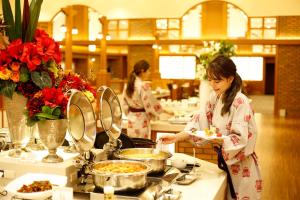 a woman is preparing food in a buffet at Dogo Prince Hotel in Matsuyama