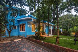 niebieski dom z drzewem przed nim w obiekcie SaffronStays Beach Blues, Alibaug w mieście Alibag