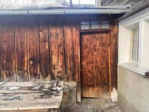 uma porta de madeira ao lado de uma casa em Tgesa Frena em Sedrun