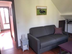 a living room with a couch and two horses on the wall at LA CHERIELLE in Auvers-sur-Oise