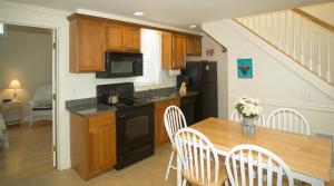 een keuken met een houten tafel en een zwarte koelkast bij Owls Head Cottage at One Long Beach in York Beach