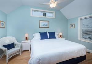 een blauwe slaapkamer met een bed en een stoel bij Owls Head Cottage at One Long Beach in York Beach