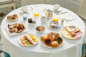 uma mesa branca com pratos de pequeno-almoço em Grand Hotel de la Ville em Sorrento