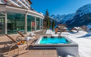 a house with a swimming pool on a patio at Hotel Waldegg - Adults only in Engelberg