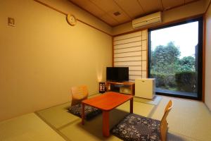 une chambre avec une table, des chaises et une fenêtre dans l'établissement リバティーリゾート久能山, à Komagoe