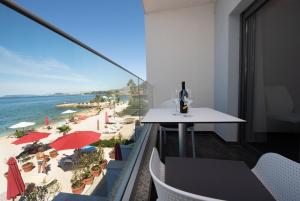 balcone con tavolo e vista sulla spiaggia di Luxury rooms Beach Mediteran a Podstrana