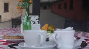 una mesa con tazas y platos blancos y fruta en ella en Hotel Luis V Santo Domingo, en Santo Domingo