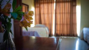 un jarrón con flores amarillas sentado en una mesa en Hotel Luis V Santo Domingo, en Santo Domingo