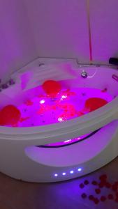 a white bath tub with pink lights in a room at Nid d'amour baignoire/jacuzzi in Nice