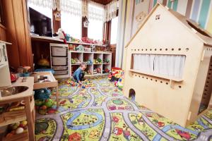 un enfant jouant dans une salle de jeux avec une maison de jouets dans l'établissement Willa Roztoka & SPA - idealne miejsce dla Twojej rodziny, à Bukowina Tatrzańska