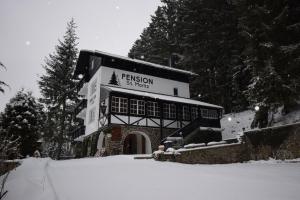 um edifício com um sinal na neve em Pension St. Moritz em Železná Ruda