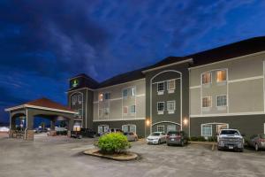 BroussardにあるLa Quinta Inn & Suites by Wyndham Broussard - Lafayette Areaの駐車場に車を停めた大型ホテル