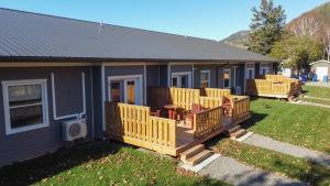 een huis met een terras met stoelen erop bij Motel L'Abri in Carleton sur Mer