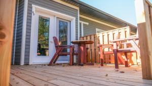 een veranda met twee stoelen en een tafel op een huis bij Motel L'Abri in Carleton sur Mer