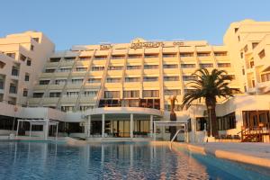 um hotel com piscina em frente a um edifício em Hotel Atlantida Sol na Figueira da Foz