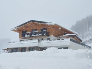 dom pokryty śniegiem z przodu w obiekcie Appartment Sonnenwiese w mieście Finkenberg