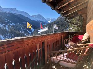 een balkon met stoelen en vlaggen op een berg bij Sonniges Chalet Arosa für 6 Pers alleinstehend mit traumhaftem Bergpanorama in Langwies