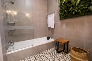 ein Badezimmer mit einer Dusche, einer Badewanne und einem Stuhl in der Unterkunft Siji Gempol Vacation Home in Yogyakarta